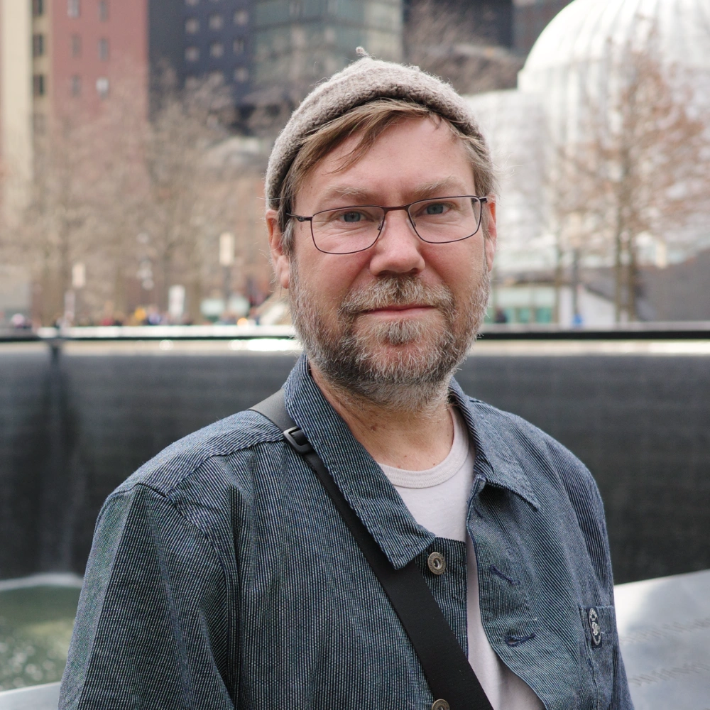 Chris Lorensson, photographed outdoors in a knit cap and chambray shirt