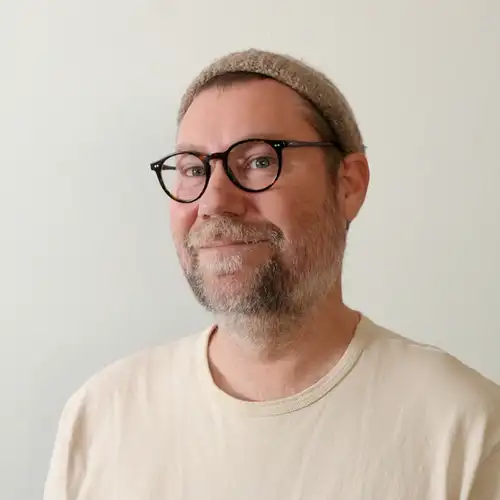 Chris Lorensson, photographed indoors in a knit cap and light t-shirt